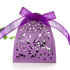 Macro detail of purple laser-cut wedding favor box with pearl paper and silk ribbon