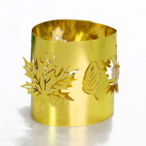 Close-up of golden hollow leaf napkin ring featuring intricate laser-cut maple patterns