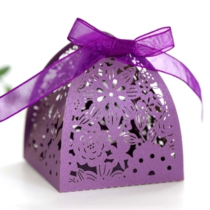 Detailed laser-cut hollow floral pattern on purple metallic gift box with ribbon