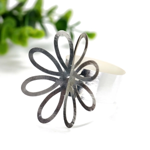 Macro detail of a silver hollow petal napkin ring with reflective metallic finish