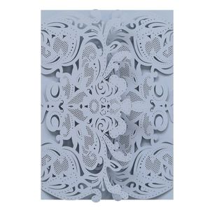 Macro detail of laser-cut floral pattern on cold grey card for wedding invitation