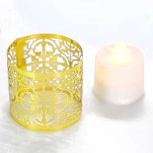 Detail of golden metal hollow candle sleeve with European pattern and LED tea light