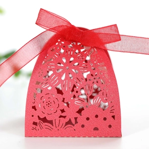 Close-up of red laser-cut candy box featuring floral patterns and a sheer organza ribbon