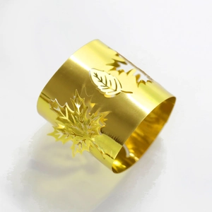 Close-up of golden maple leaf napkin ring with polished mirror finish and hollow detail