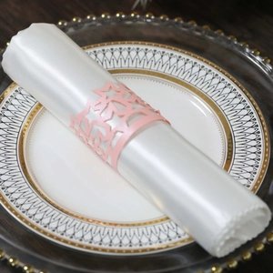 Macro detail of laser-cut pink star napkin ring with pearlescent finish on silk napkin
