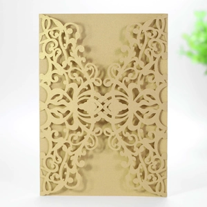 Detail of laser-cut gold pearlescent paper invitation with ornate filigree patterns