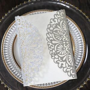 Detailed laser cut lace wedding invitation with silver glitter on off-white pearlescent paper