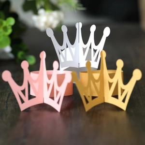 Intricate hollow crown napkin rings in gold, pink, and white for party table decoration