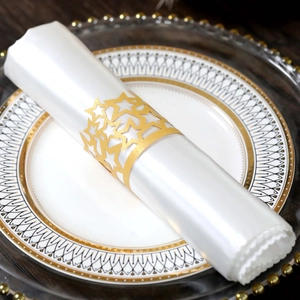 Close-up of golden hollow star napkin ring on a white napkin for wedding table setting