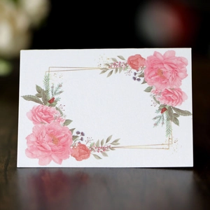 Macro detail of rectangle place card with pink floral pattern and elegant gold border