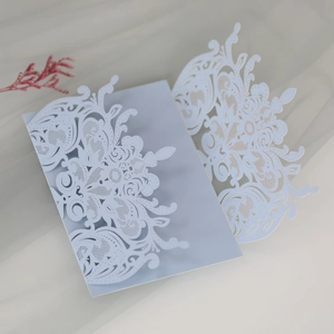 Detail of light blue laser-cut wedding invitation with intricate baroque floral patterns