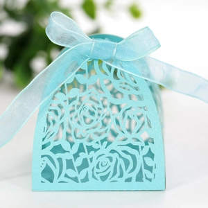 Detailed laser-cut rose patterns on a light blue wedding gift box with organza ribbon