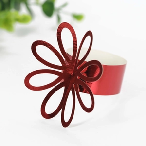 Detail view of red floral napkin rings with hollowed-out petals and glossy mirror finish