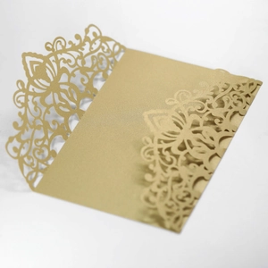 Macro view of gold laser-cut lace wedding invitation made of shimmering pearl paper