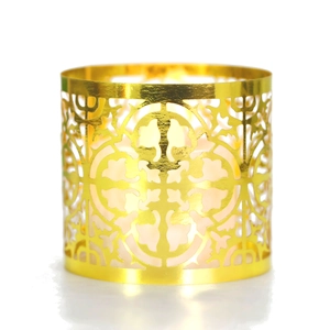 Detailed view of hollow golden metal candle holder with intricate geometric floral patterns