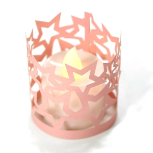 Paralume a stella in carta rosa traforata con candela LED a luce gialla calda