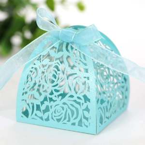 Close-up of light blue laser-cut rose candy box with an elegant organza ribbon bow