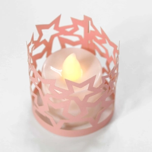 Dettaglio del paralume in carta rosa a stella con candela LED per decorazioni di festa