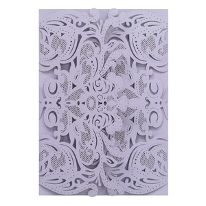 Macro detail of laser-cut lavender invitation cover with intricate floral lace patterns