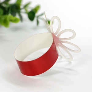 Detail of red metallic napkin ring with delicate white hollowed-out paper flower decoration