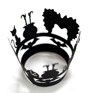 Black hollowed-out Halloween cupcake wrappers featuring bats, pumpkins, and witches