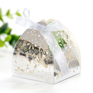 Close-up of hollow laser-cut silver wedding gift box with white satin bow decoration