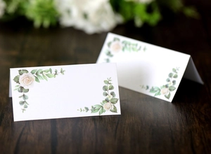Detail of elegant white rose and eucalyptus watercolor print on a folded wedding place card
