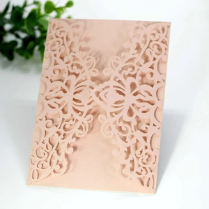 Close-up of laser-cut hollow pattern on pink pearlescent paper wedding invitation