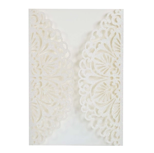 Close-up of white glitter laser-cut lace wedding invitation with hollow floral pattern