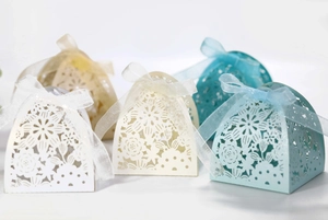 Detailed laser-cut flower patterns on elegant wedding favor gift boxes with ribbon bows