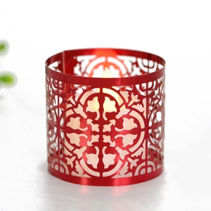 Close-up of a red hollow metal candle holder with warm LED electronic candle light