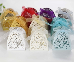 Detailed laser-cut floral wedding favor boxes with elegant satin ribbons in various colors
