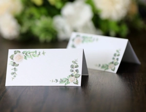 Detail of elegant white rose wedding place cards with botanical floral print on cardstock