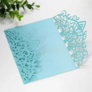 Detailed laser-cut floral pattern on light blue pearlescent wedding invitation cover
