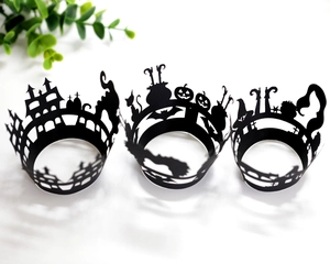 Laser-cut Halloween cupcake wrappers with spooky castle and bat motifs in black paper