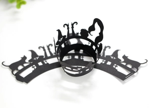 Detail of black laser-cut Halloween cupcake wrappers with witch and cat silhouettes