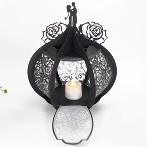 Detailed laser-cut paper lantern featuring wedding couple silhouette and rose pattern