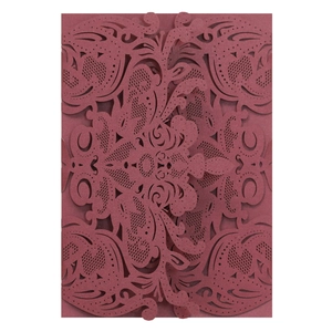 Close-up of laser-cut burgundy wedding invitation with European floral patterns