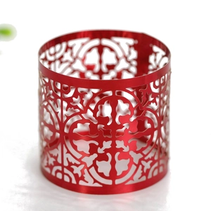 Macro shot of red metallic cutout napkin ring with traditional festive hollow patterns