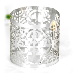 Detailed close-up of silver hollow metal napkin ring with intricate laser-cut patterns