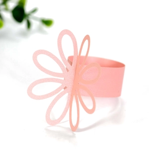 Close-up of pink petal paper napkin ring with a delicate hollow flower design