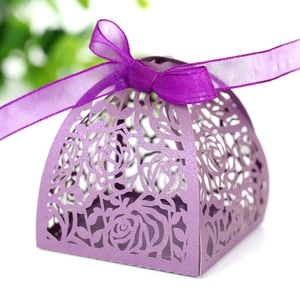 Detail of laser-cut rose patterns on deep purple pearlescent paper candy box with ribbon