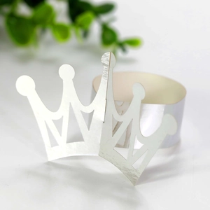 Detailed view of laser-cut crown napkin ring in reflective silver paper for party