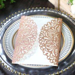 Macro detail of laser-cut rose gold glitter wedding invitation with mandala lace pattern