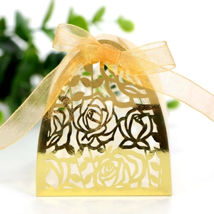 Detail of laser-cut rose hollow candy box in gold finish with elegant organza ribbon bow