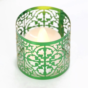 Detail of green laser-cut metal candle holder with intricate damask patterns and LED light