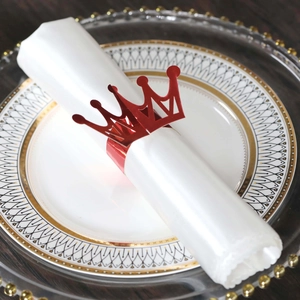 Close-up of red crown paper napkin rings set on white napkins for wedding table decor