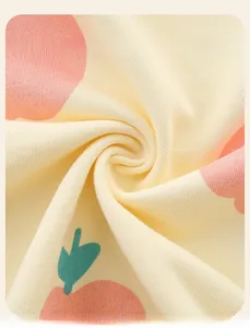 Close-up of soft cotton fabric with pink apple print and green leaves for toddler hoodies