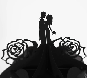 Detail of laser-cut black wedding silhouette decoration with elegant rose pattern