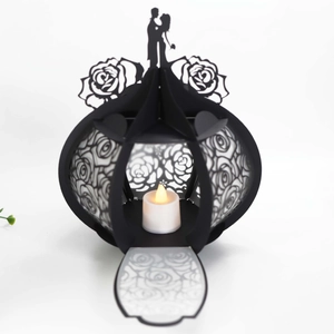 Detail of laser-cut black paper lantern with rose patterns and LED candle glow